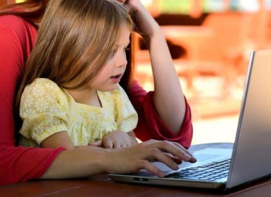 Child and Caregiver in front of a laptop